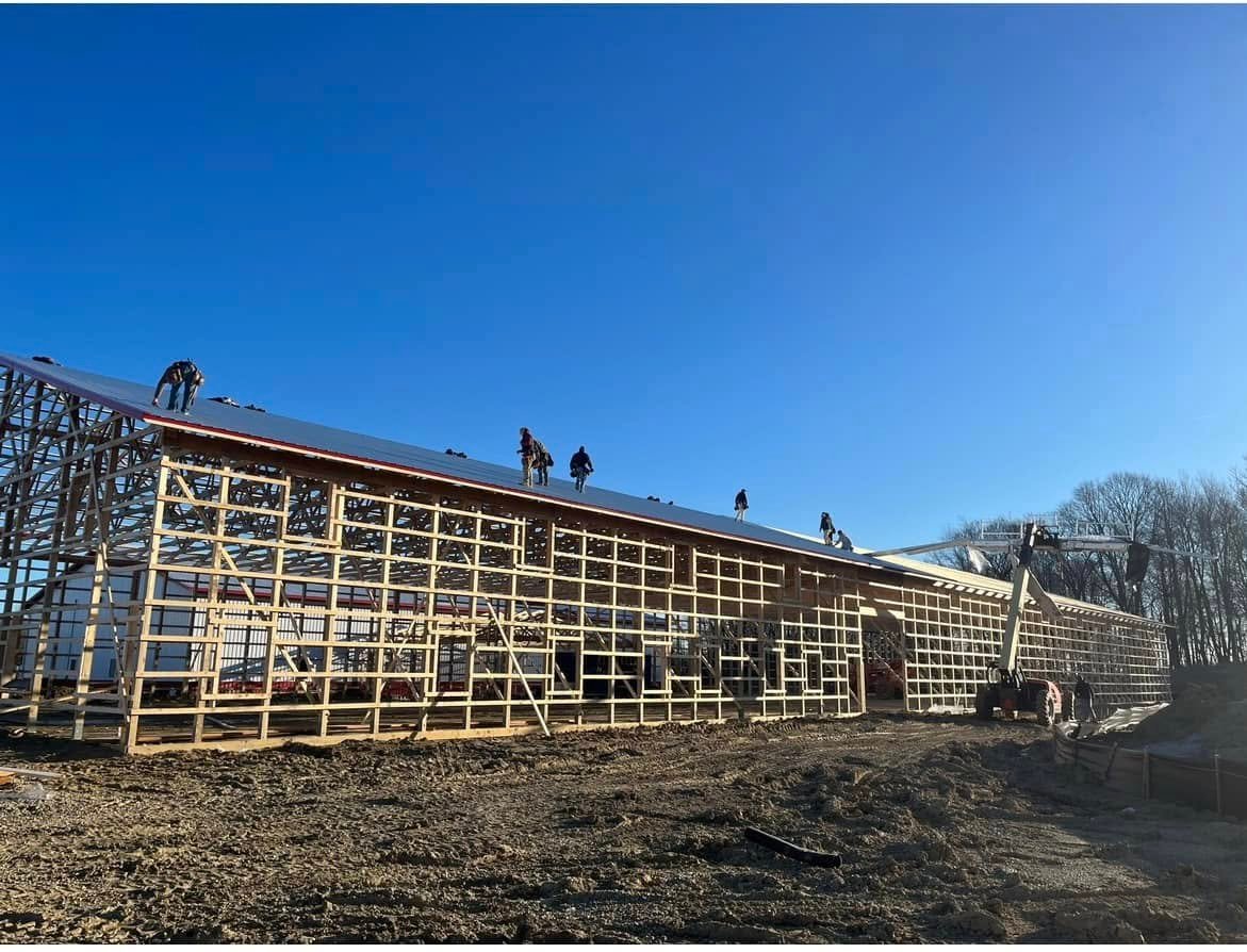 Crew putting the roof on a large pole barn build by Hershberger Construction